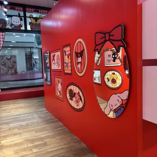 Red gallery wall with framed Sanrio character artwork inside the Hello Kitty pop-up.
