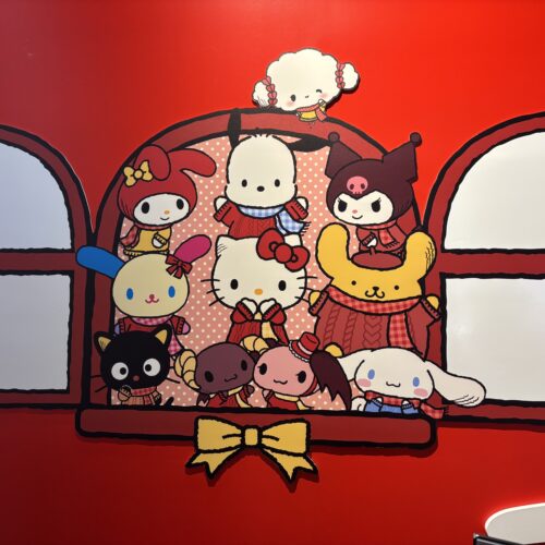 Hello Kitty and Friends window mural painted onto the red scenic wall.