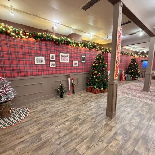 Decorated Christmas tree and garland lighting inside Santa’s Workshop at Six Flags.