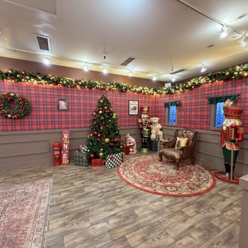 Christmas tree, nutcracker props, and holiday photo area inside Six Flags Santa’s Workshop.